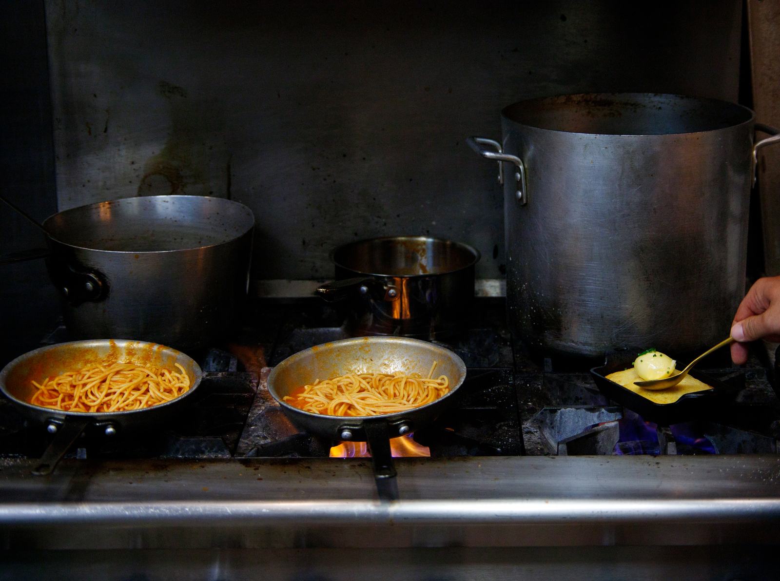 Pans of pasta finishing over the burners on Solera's line